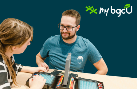 A BGC staff person and club member engage in a game of Battleship